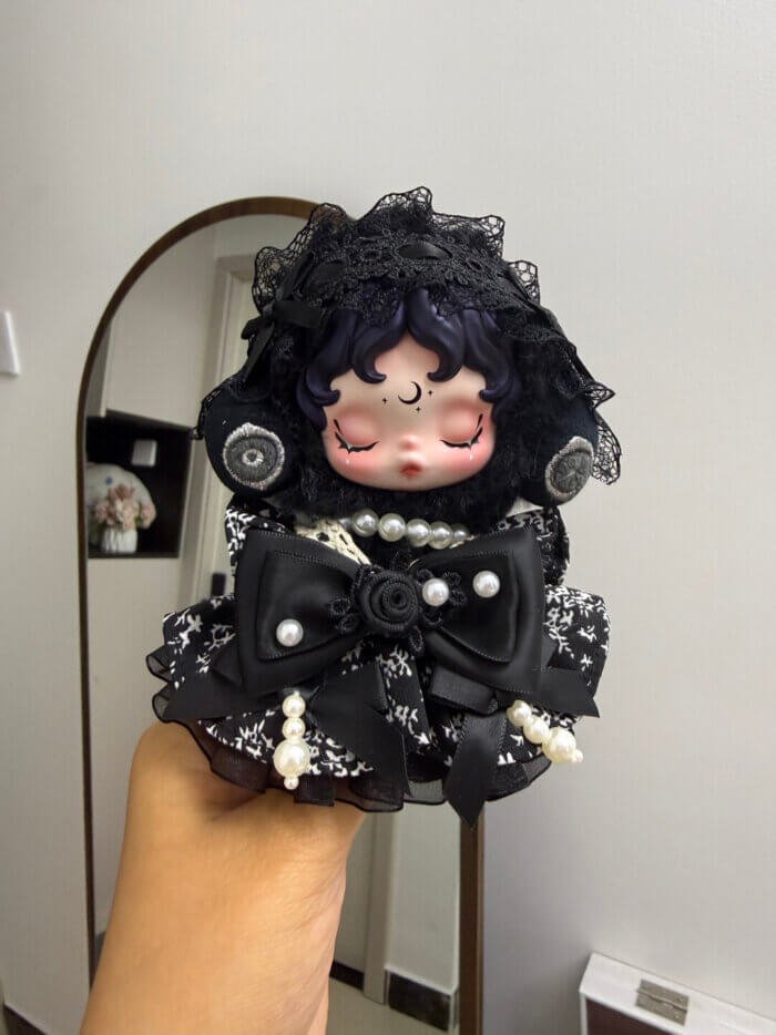 Nahaufnahme von Skullpandas gotischem Himmelsoutfit mit spiralförmigen Ohrenschützern und Mondmotiv