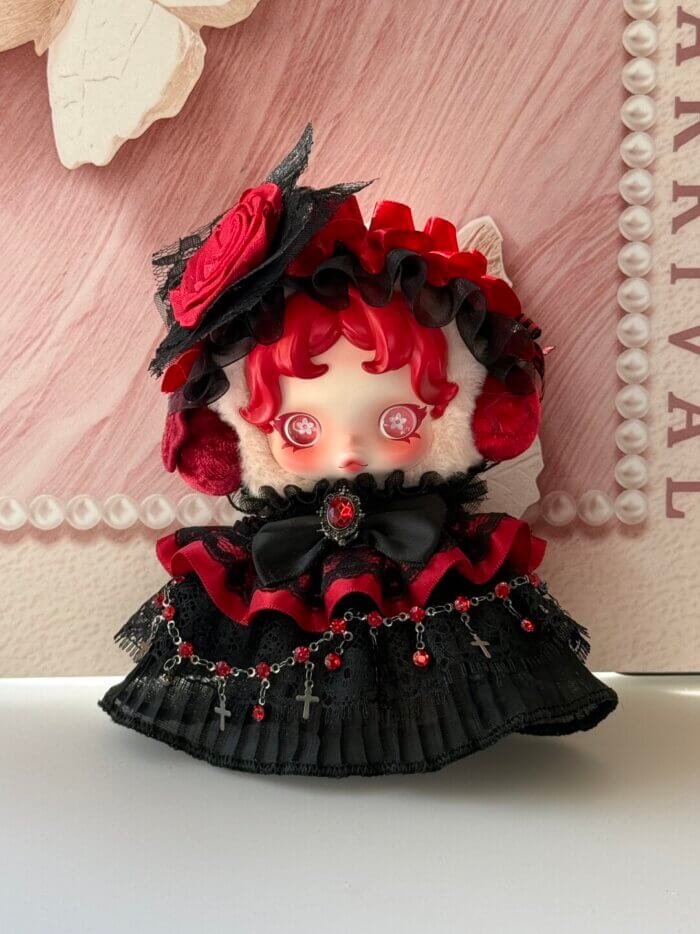 Gros plan sur la tenue Skullpanda Chomp rose rouge avec chaînes de perles et détails de la jupe en dentelle